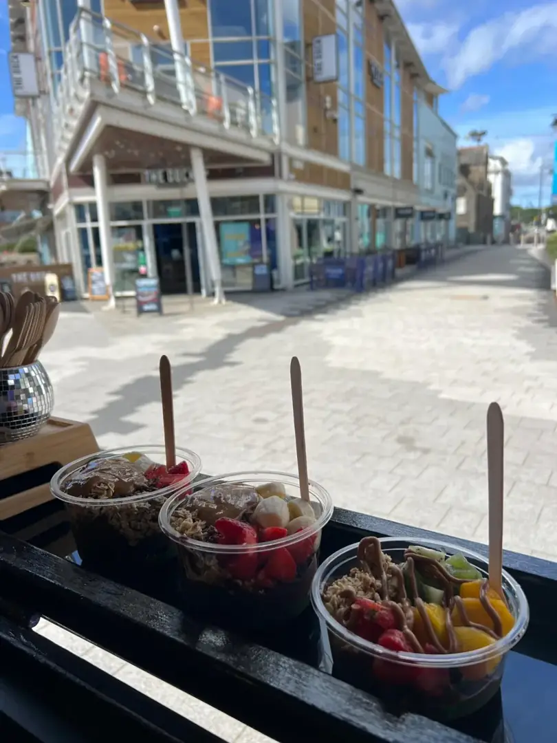 Three freshly topped açaí bowls lined up at The Açaí Bar’s serving hatch.