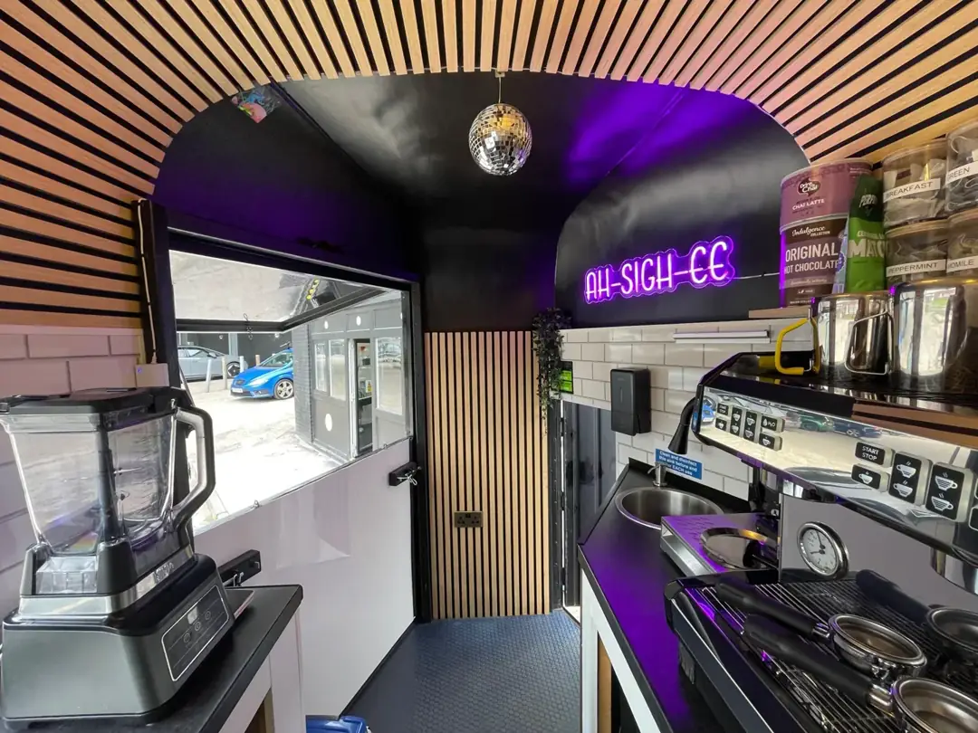 The inside of the horsebox with wood ceiling and purple neon